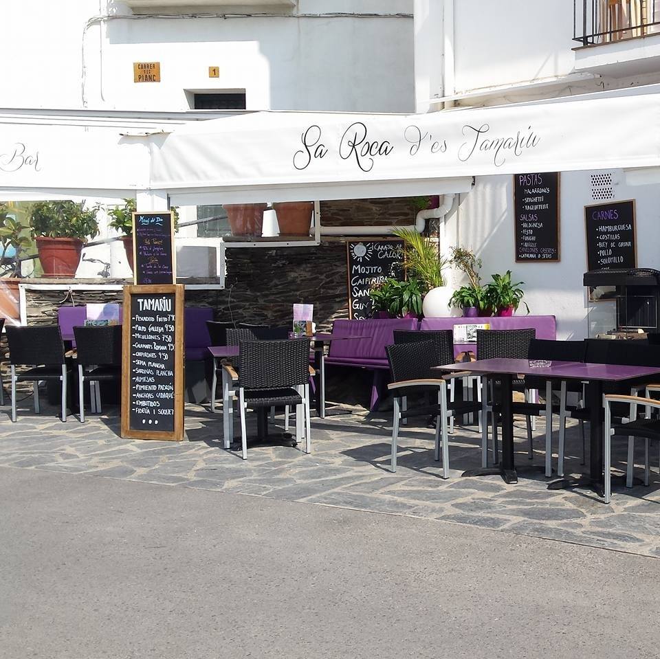 Terraza con las mesas y sillas puestas del restaurante Sa Roca